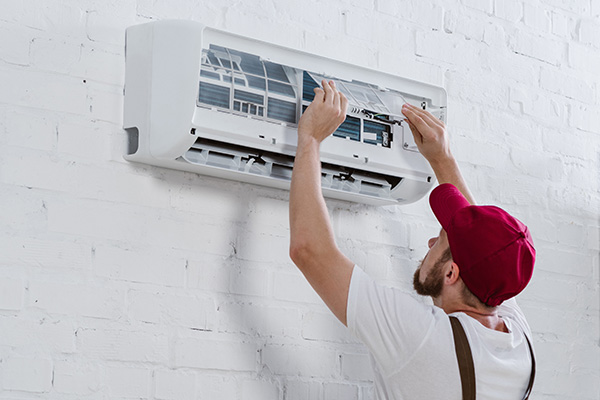 Repairman servicing air-conditioning unit.